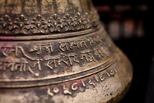 close up of inscription on a bell in a temple in nepal.
