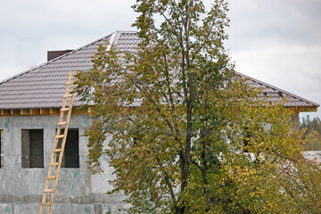 Side view of a two-story residential building under construction with unglazed Windows