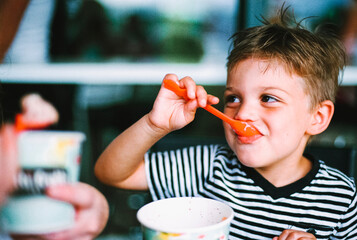 Young boy eating frozen yogurt
