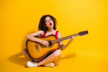 Portrait photo of hipster female musician with curly hair singing vocal voice song holding keeping...
