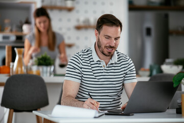 Young man working on project. Handsome man working at home.