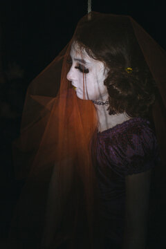 Side view of a face painted girl with rope at halloween