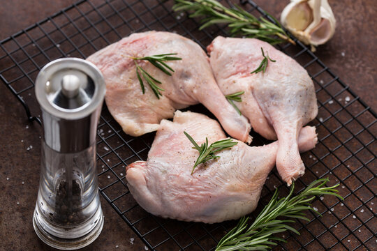 Raw duck legs on a wire rack
