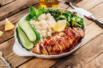 Keto lunch bowl. Grilled chicken with cauliflower rice, broccoli and cucumber.