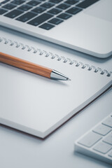 Closeup shot of brown pen with notebook and laptop on workspace.