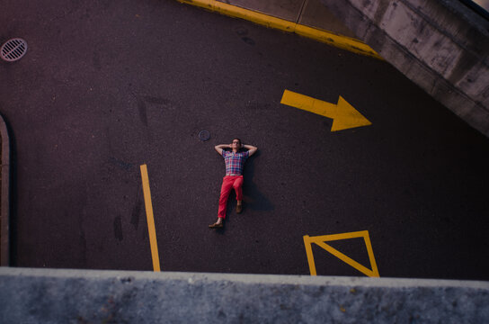 Stylish man laying on a one way street