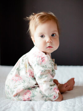 Cute baby sitting on a bed