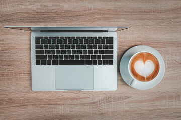 Office desk table with laptop and coffee cup.