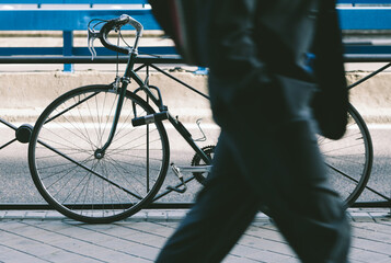 Bussinesman Walking Besides a Parked Bicycle