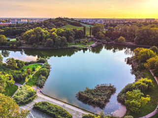 Fototapeta na wymiar Park with large lake in the big, capital city. Drone, aerial view