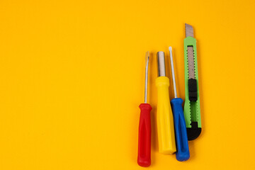stationery knife screwdrivers and construction tools on yellow background equipment for repair industry