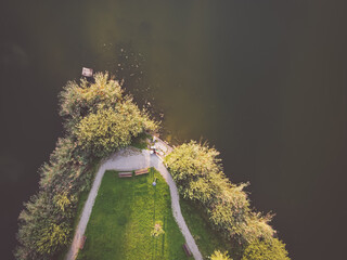 Top down view of lake and alleys in the park with reflection of clouds. Drone, aerial view