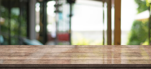 Empty wooden table top with lights bokeh on blur restaurant background, wood table banner