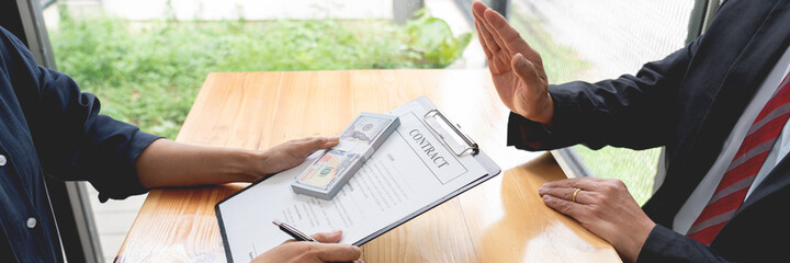 Confident businessman manager rejecting an offer of money to agreement contract from partner or refusing to take bribe, Bribery and corruption concept.