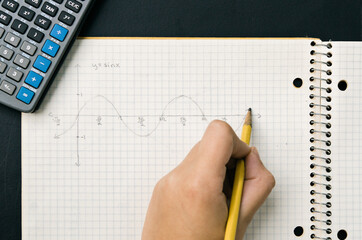 student drawing a trigonometry graph