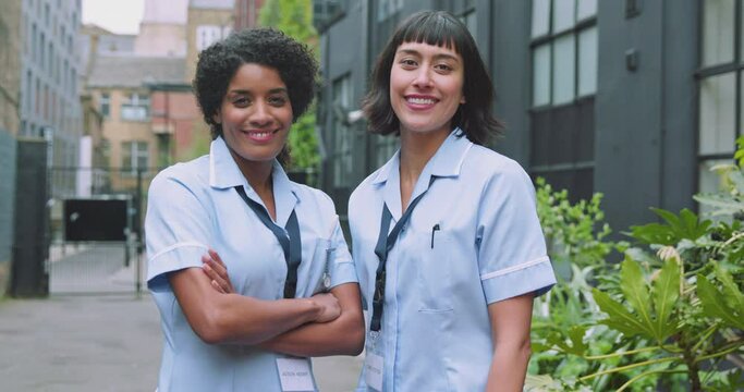 Portrait of two woman in scrubs looking into camera smiling