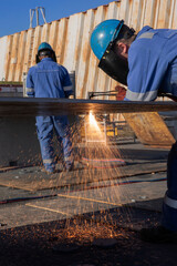 Cutting iron plate with cutting torch. Metal cutting a hole. Shipyard. Shipbuilding industry. Sparks.