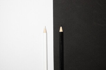 two black and white wooden pencils on a black and white background.