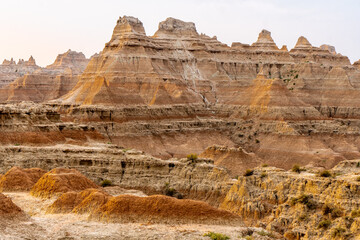 Sharp and round mounds of layered sedimentary rock with summits and ridges with horizontal lines in the soft morning light, Badlands National Park, South Dakota