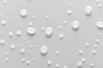 Full background of water droplets, moisture or condensation on a white background. Liquid drops on bathroom tile or smooth surface.