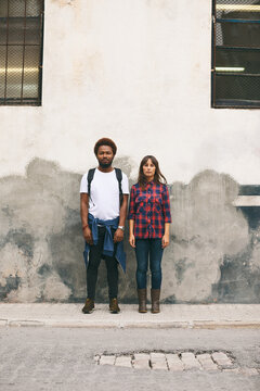 Young couple standing in old wall.