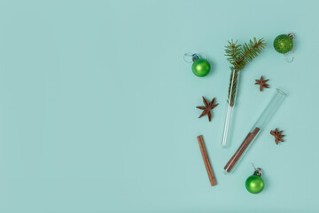 Christmas composition of test tubes, festive balls, cinnamon and star anise on a mint background...