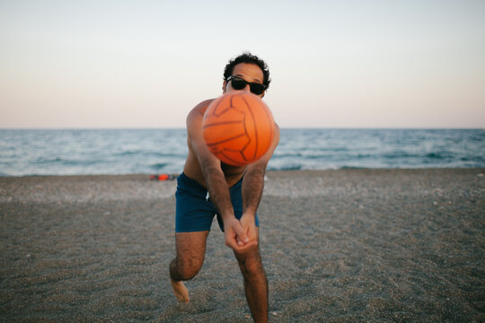Young man playing volleyball on the beach