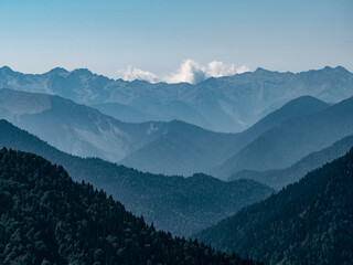 Layered mountains range at sunny day. Blue gradient background