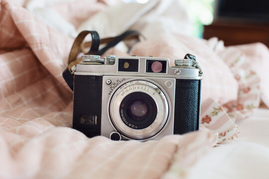Close up of vintage reflex camera on pink bed
