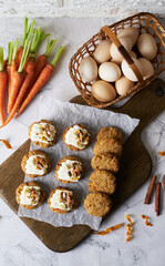 Keto Carrot oatmeal cookies. Healthy homemade ketogenic diet dessert decorated with white cream, nut and seeds. set on white cafe table background.