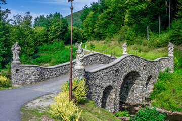 old stone bridge in the woods with statues
