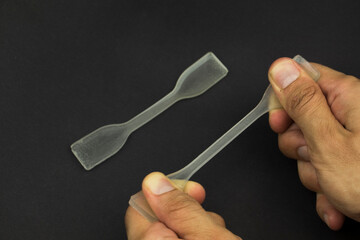 polydimethylsiloxane (pdms) polymer sample which is using in engineering experiments. it is a tensile test specimen to examine the strength of the material.
