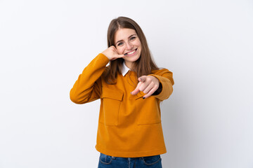 Young woman over isolated white background making phone gesture and pointing front