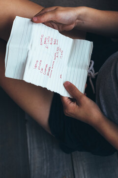 Teenage girl holding a written list of things she is saving her money to buy