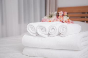 Fototapeta na wymiar White towels and beautiful frangipani or plumeria flowers in bamboo wooden basket on modern white bedroom