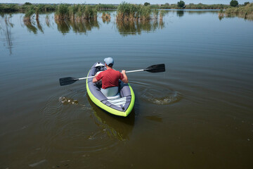 young male swim on kayak on the river