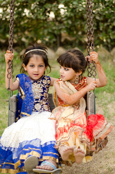 Two Baby Girls enjoying a ride on a swing