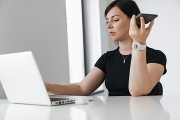 Confident young business woman working on laptop