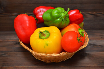 basket of vegetables bell peppers and tomatoes on a dark background