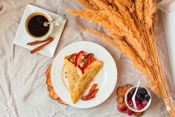 gluten-free crepes with fresh peach and almonds, a cup of coffee and sweet berries. top view. autumn healthy breakfast or dessert concept