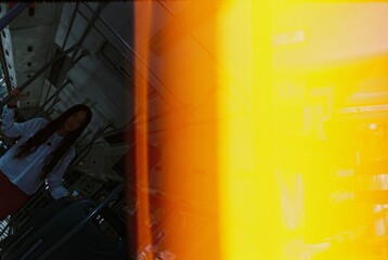 Light leak photo of a young Asian woman on the bus. Image shot by old film camera