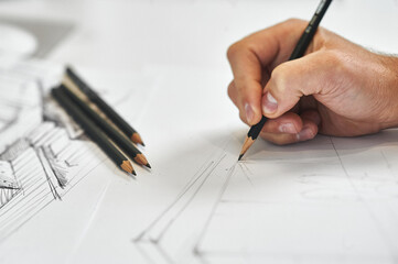 Creative architect and interior designer working on hand drawing architectural sketch with black pencil