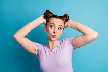Obraz na płótnie Canvas Photo of attractive teen lady touch check nice hairstyle two funny pretty buns hairdo like new style look flirty empty space send kisses wear casual t-shirt isolated blue color background