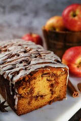 Homemade Apple Fritter Bread drizzled with white glaze on fall autumn background, selective focus
