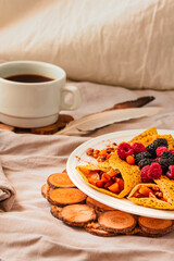 Gluten-free crepes stuffed with roasted pear, walnut and cinnamon, in the oven with fresh berries on top. Autumn comfort breakfast served on a natural linen background. Selective focus. Free space for