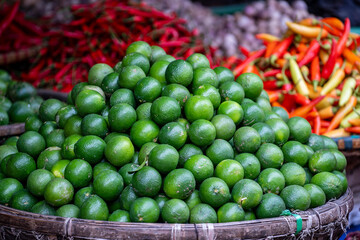 Green oranges for sale at street food market in the old town of Hanoi, Vietnam
