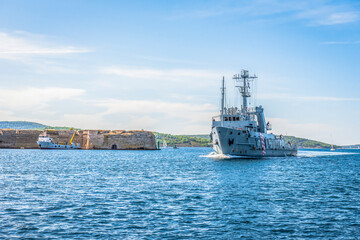 Warship entering the bay past the medieval fortress near the town of Sibenik in Croatia