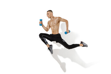 Running, jumping high. Stylish young male athlete on white studio background, portrait with shadows. Sportive fit model in motion and action. Body building, healthy lifestyle, style concept.