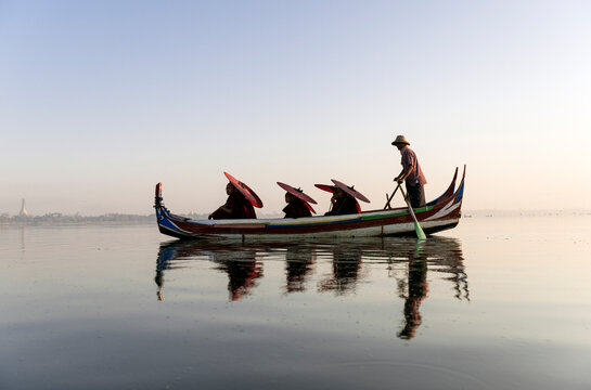 Buddhist monks in small rowing boat during sightseeing tour