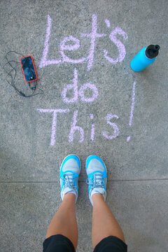 Female before a work out - chalk words that say Let's do this!